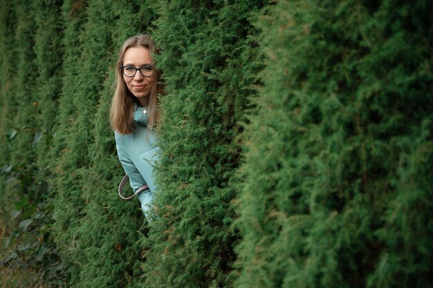 Herbstporträt der schönen Frau auf Thuja-Naturhintergrund