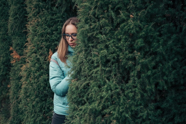 Herbstporträt der schönen Frau auf Thuja-Naturhintergrund