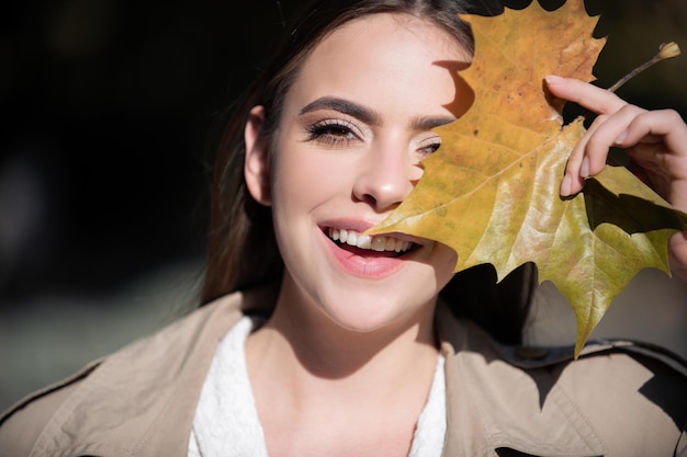 Herbstporträt einer fröhlichen Frau mit gelben Ahornblättern Porträt eines schönen Mädchens mit Herbstblättern