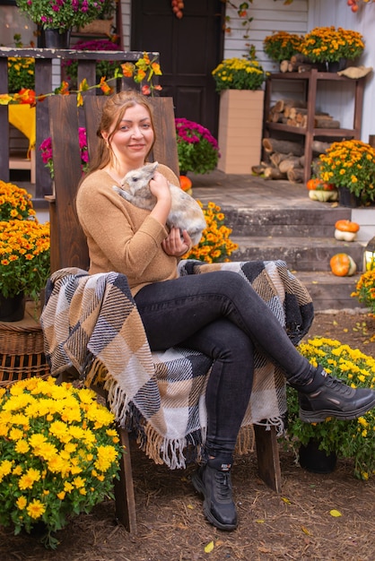 Herbstporträt einer glücklichen jungen Frau in der Nähe von zu Hause