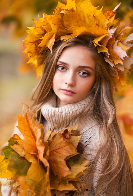 Herbstporträt einer jungen Frau nahe Herbstlaub