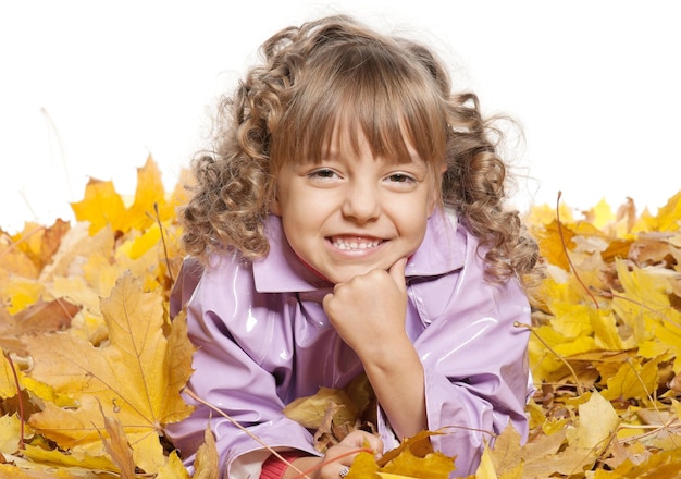 Herbstporträt von süßem lächelndem kleinen Mädchen mit ahornfarbenen Blättern, isoliert auf weißem Hintergrund