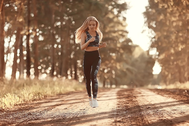 Herbstsport für erwachsenes Mädchen / schönes aktives Mädchen, das in der Herbstsaison Outdoor-Sportarten läuft und praktiziert