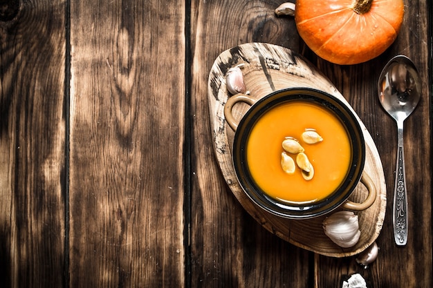 Herbststil. Frische Kürbissuppe. Auf hölzernem Hintergrund