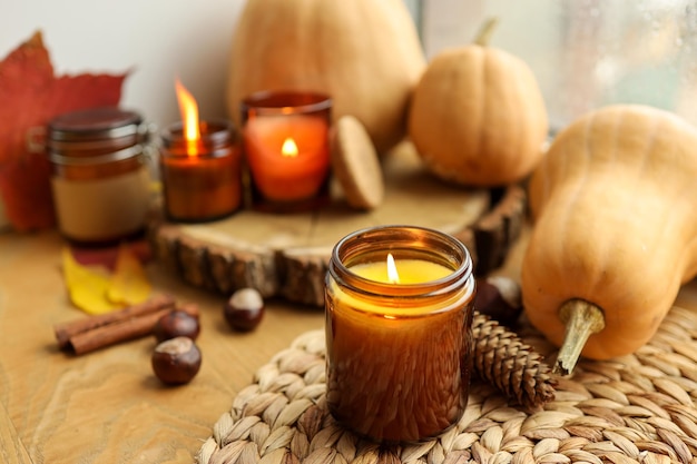 Herbststillleben auf der Fensterbank eine brennende Kerze, Kürbisse und Kerzen