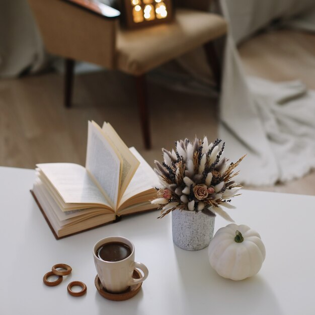 Herbststillleben mit Kaffeetasse Blumenbuch und Kürbis Hygge Lifestyle gemütliche Herbststimmung