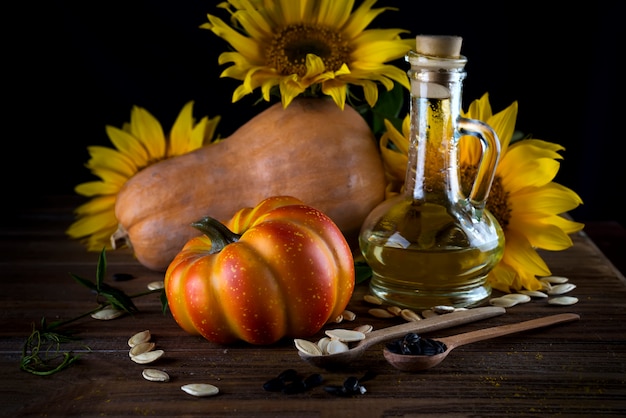 Herbststillleben mit kürbissen, öl und sonnenblumen