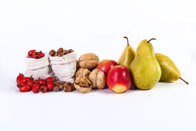 Herbststillleben mit Obst Äpfel Birnen Nüsse Hagebutten isoliert auf weißem Hintergrund