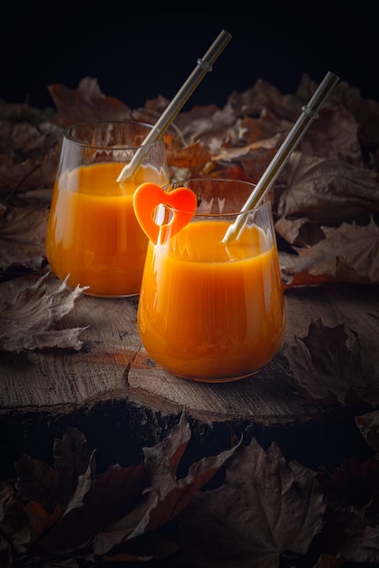 Herbststillleben mit Pfirsichsaft und abgefallenen Blättern