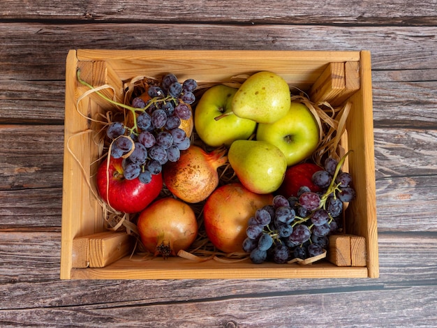 Herbststillleben Verschiedene Früchte, Gemüse und Kürbis in die Kiste auf dem Holztisch
