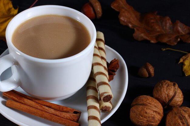 Herbststillleben von Cappuccino, Nüssen und Süßigkeiten