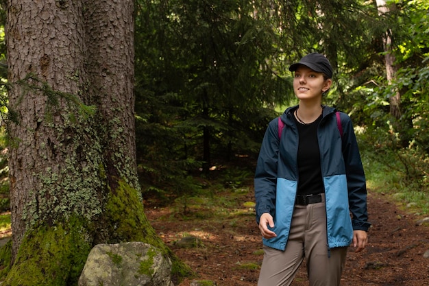 Herbstwanderung, touristischer Lebensstil, Frau, die auf einem Wanderweg im Wald im Freien spaziert. Aktives Mädchen im Sommer und Herbst mit Rucksack beim Wandern im Freien