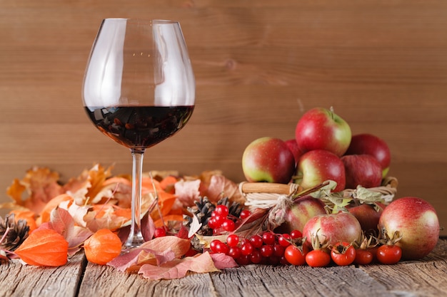 Foto herbstwein im glas auf rustikalem holzraum