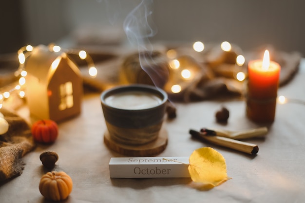 Herbstzeit gemütliche hygge Wohnkultur mit einer Tasse Kerzen karierten Halloween und Thanksgiving-Konzept