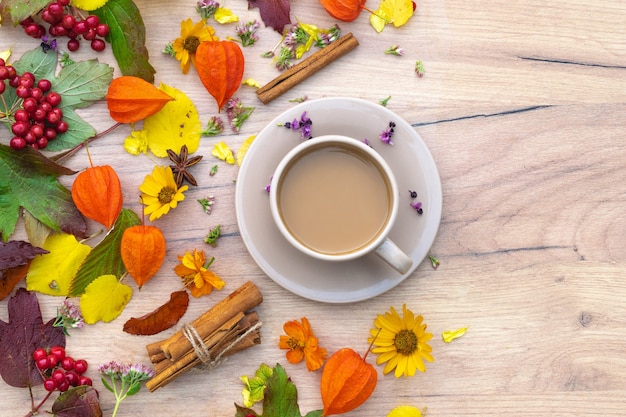 Herbstzusammensetzung Tasse Kaffee auf einem Tisch mit Blumen und Blättern Draufsicht Hintergrundbild