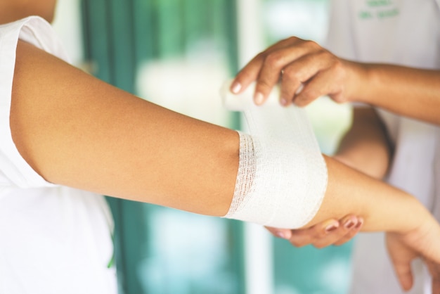 Foto herida de codo vendaje brazo por enfermera