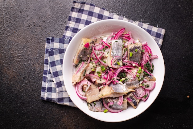 Heringsscheibe Zwiebel eingelegter gesalzener Fisch Meeresfrüchte frischer Snack auf dem Tisch Kopienraum Essen