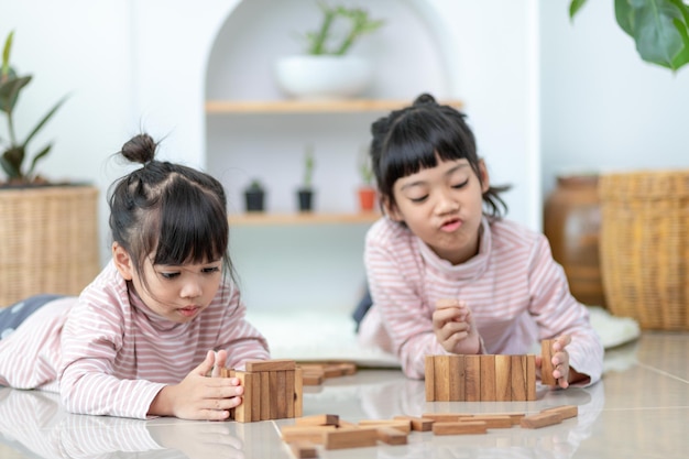 Hermana asiática jugando pilas de madera en casa