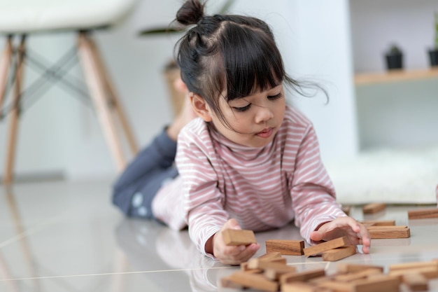 Hermana asiática jugando pilas de madera en casa