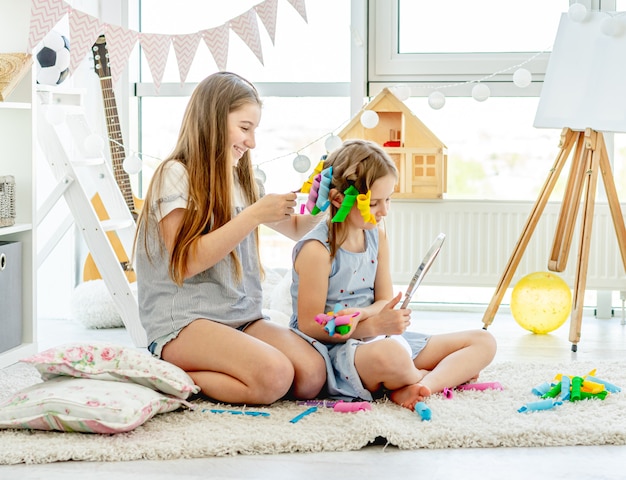 Hermana haciendo peinado a niña