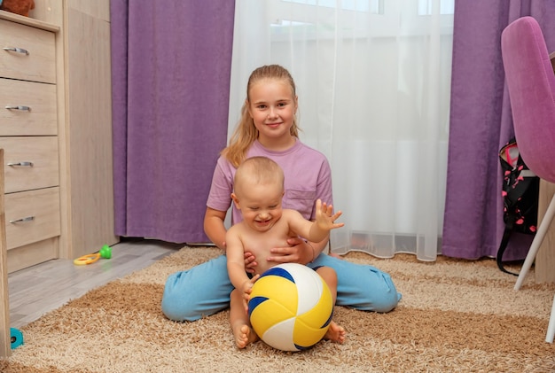 Foto hermana y hermanito con una pelota