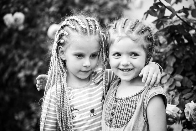 Hermana rastas divirtiéndose spring garden al aire libre Niñas sonrientes en el parque Niña jugando al aire libre Divirtiéndose al aire libre