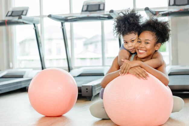 Una hermana sana con un niño disfruta sonriendo feliz jugando juntos en el gimnasio deportivo