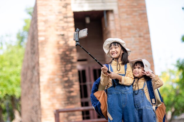 Hermanas asiáticas tomando selfies. tomar fotos autofotos con un teléfono inteligente