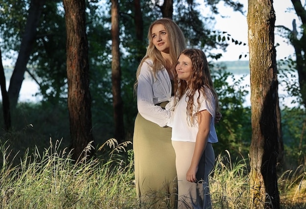 Las hermanas en el bosque se paran y miran el sol.