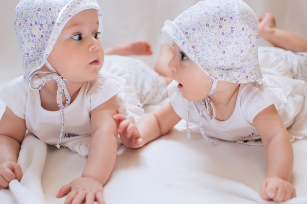 Hermanas gemelas felices en casa en la cama