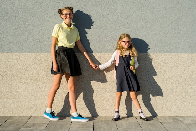 Hermanas lindas colegiala en uniforme escolar.