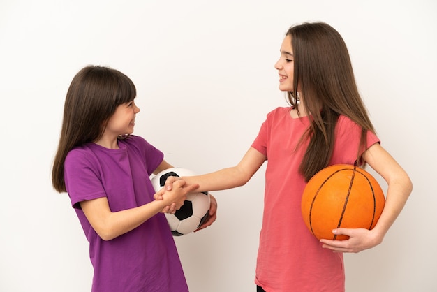 Hermanitas jugando al fútbol y baloncesto aislado sobre fondo blanco apretón de manos después de un buen trato