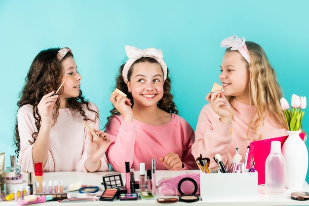 Hermanitas en maquillaje de moda retro con pañuelo en la cabeza para niños grupo de amigos felices en la fiesta de la amistad del spa con relajación cosmética y divirtiéndose niñas pequeñas en el salón de belleza Jóvenes y hermosas