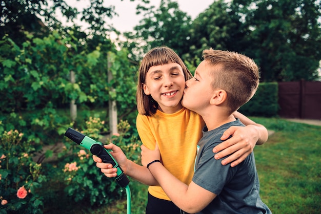 Hermano besando y abrazando a su hermana al aire libre