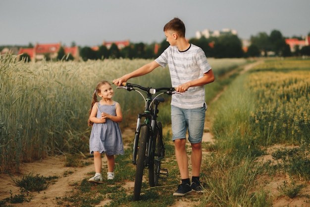 hermano y hermana andar en bicicleta por un campo de trigo