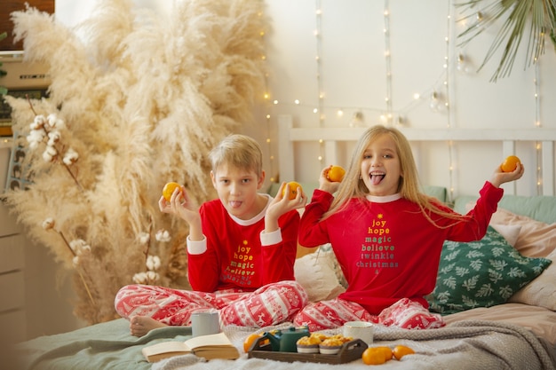 Hermano y hermana antes de Navidad en pijama en casa