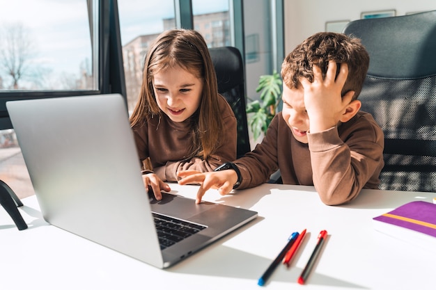 Hermano y hermana en la computadora portátil