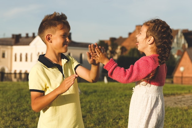 Hermano y hermana juegan al aire libre en verano.