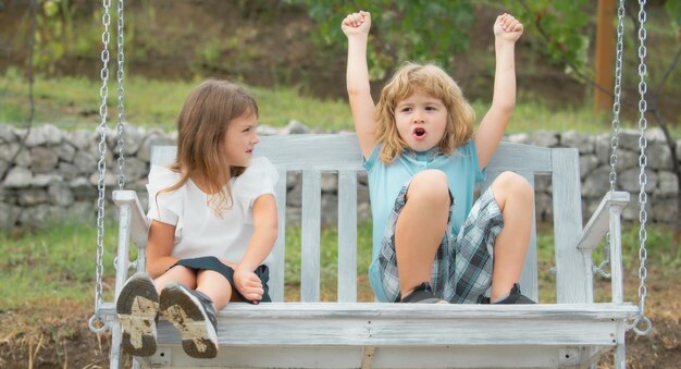 Hermano y hermana jugando afuera Pequeño niño y niña emocionados y asombrados trabajando en el jardín Dos niños felices en el parque de verano Concepto de vacaciones de vacaciones de verano para niños Amistad de los niños