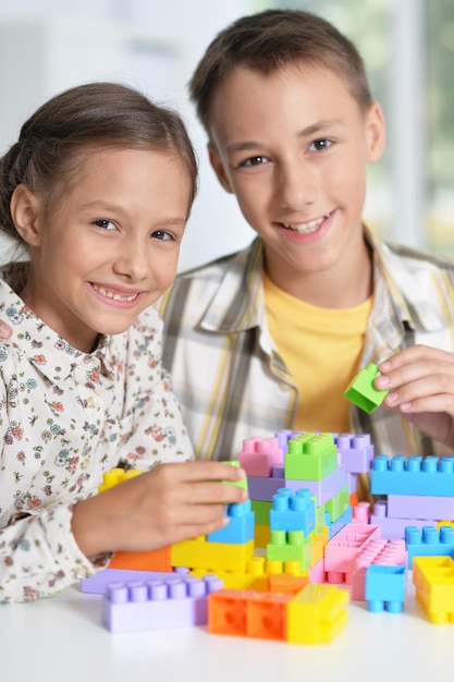 Hermano y hermana jugando con bloques de plástico