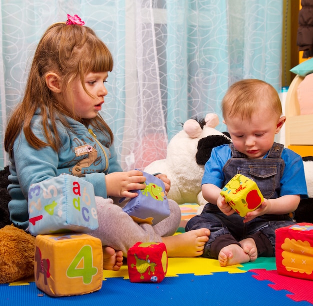 Hermano y hermana jugando con cubo de colores suaves