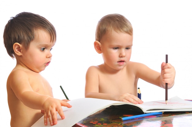 Hermano y hermana jugando con lápices de colores juntos