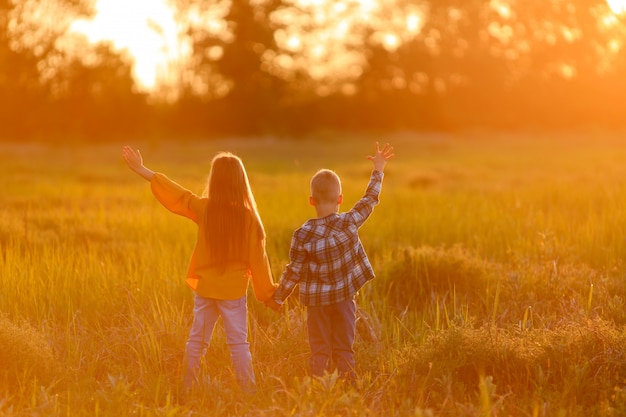 Hermano y hermana en un paseo en la naturaleza al atardecer.