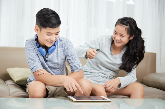 Hermano y hermana peleando por tableta