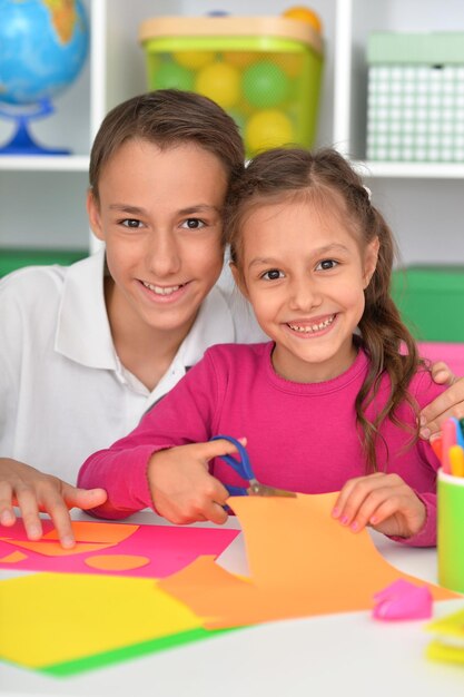 Hermano y hermana sentados a la mesa y pasando tiempo juntos