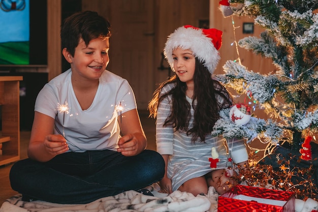 hermano y hermana sosteniendo bengalas el milagro navideño