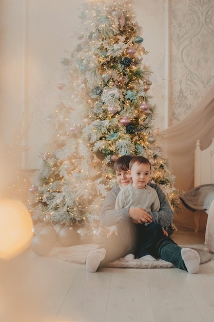 hermanos bajo el arbol de navidad