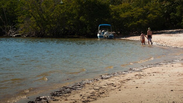 Hermanos caminando por la playa en Diez Mil Islas.