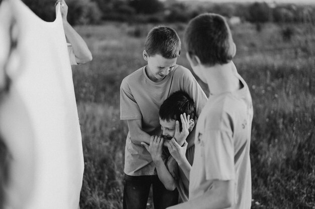 Hermanos chicos divertidos en una camiseta naranja jugando al aire libre en el campo al atardecer estilo de vida de los niños felices