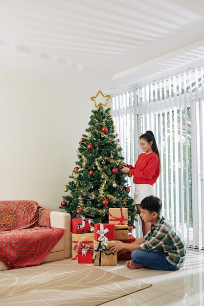 Hermanos decorando el árbol de navidad